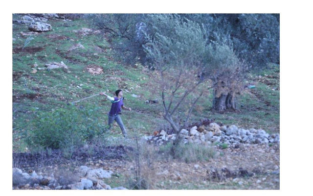 Un jeune Palestinien près de la barrière de sécurité à Bilin (Crédit : autorisation IDF)