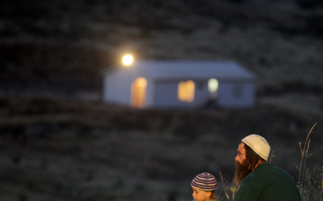 Un homme et son fils près de l'avant-poste de Havat Gilad (Crédit: Nati Shohat/ Flash 90)