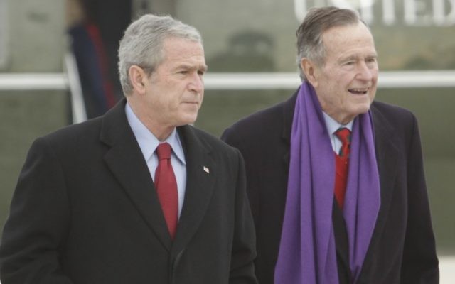 Le président George W. Bush marche aux côtés de son père, George H.W. Bush, à droite, sur la base de l'armée de l'air  Andrews, dans le Maryland, en décembre 2008 (Crédit : AP/Evan Vucci)