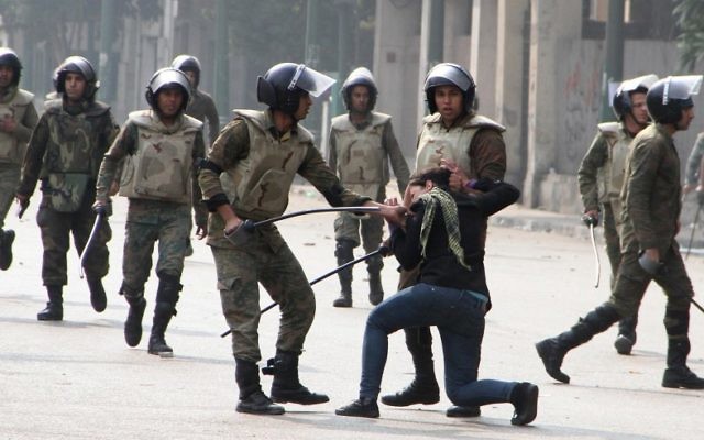 Egyptian army soldiers arrest a woman protester during clashes in Cairo's Tahrir Square on December 16, 2011 (photo credit: AP Photo/File)