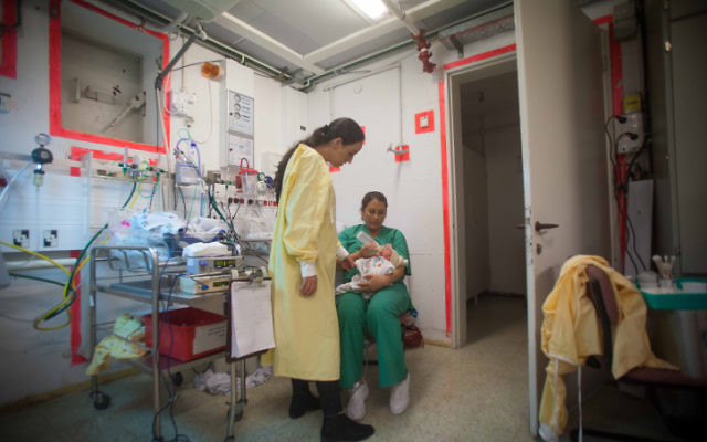 Une infirmière s'occupe d'un nourrisson dans un abri de l'hôpital Barzilai alors qu'une sirène retentit, avertissant de l'arrivée possible de roquettes à Ashkelon, le 15 novembre 2012. (Crédit : Uri Lenz/Flash90)