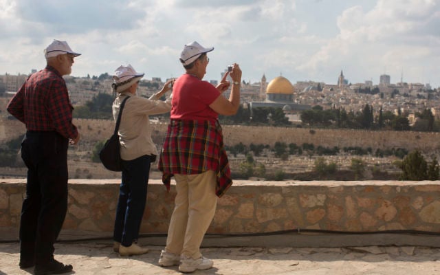 Tourists take pictures from the Mount of Olives, overlooking the walls of the Old City of Jerusalem and its distinctive golden Dome of the Rock. (photo credit: Yonatan Sindel/Flash90)