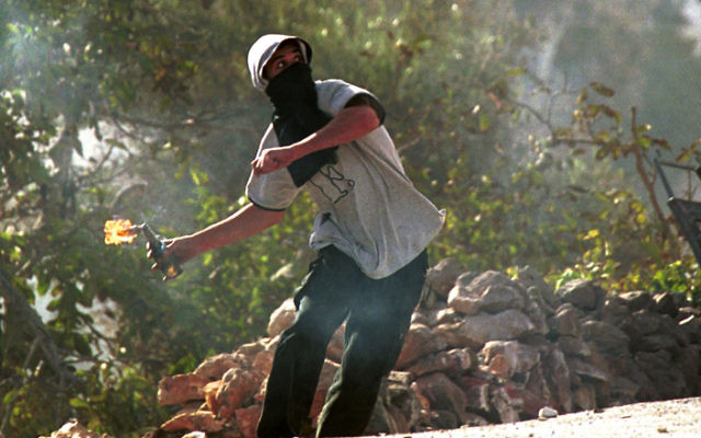 Un jeune Palestinien lance un cocktail Molotov sur des soldats israéliens près de Bethléem en 2000 (Photo illustrative : Yossi Zamir/Flash90)