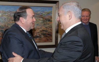 Mike Huckabee rencontre le Premier ministre Benjamin Netanyahu à Jérusalem, avec l'acteur Jon Voight en arrière plan, en 2011. (Crédit : Amos BenGershom/ GPO/Flash90)