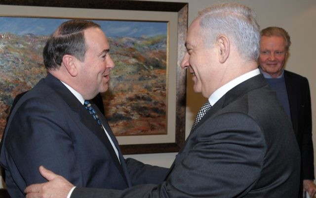 Mike Huckabee rencontre le Premier ministre Benjamin Netanyahu à Jérusalem, avec l'acteur Jon Voight en arrière plan, en 2011. (Crédit : Amos BenGershom/ GPO/Flash90)