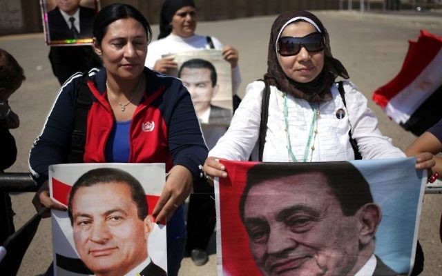 Des partisans de l'ancien président égyptien, Hosni Moubarak, brandissent des affiches de lui lors d'une manifestation devant l'académie de police du Caire transformée en tribunal, le 25 août 2013 (Crédit : AP Photo/Khalil Hamra) Des partisans de l'ancien président égyptien, Hosni Moubarak, brandissent des affiches de lui lors d'une manifestation devant l'académie de police du Caire transformée en tribunal, le 25 août 2013 (Crédit : AP Photo/Khalil Hamra)