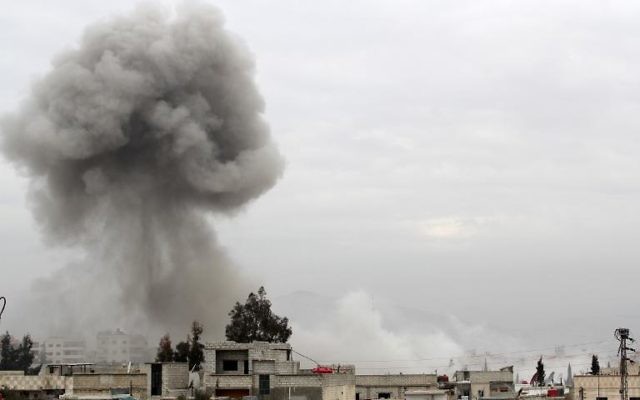 De la fumée au-dessus d'immeubles après une attaque aérienne de l'armée syrienne, le 25 janvier 2014 à Daraya, au sud-ouest de Damas (Crédit : AFP/Fadi Dirani) De la fumée au-dessus d'immeubles après une attaque aérienne de l'armée syrienne, le 25 janvier 2014 à Daraya, au sud-ouest de Damas (Crédit : AFP/Fadi Dirani)