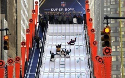 Des fans du Super Bowl glissent sur un tobogan géant à Manhattan, le 29 janvier 2014 (Crédit : AFP)