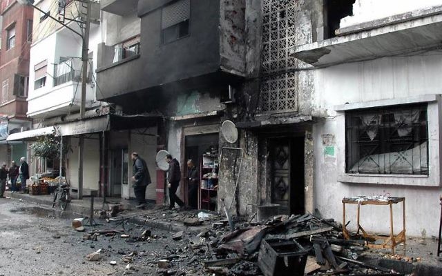 Des habitants dans une rue de Homs après des tirs au mortier de rebelles syriens, le 9 janvier 2014
(Crédit : Sana/AFP/Archives) Des habitants dans une rue de Homs après des tirs au mortier de rebelles syriens, le 9 janvier 2014
(Crédit : Sana/AFP/Archives)