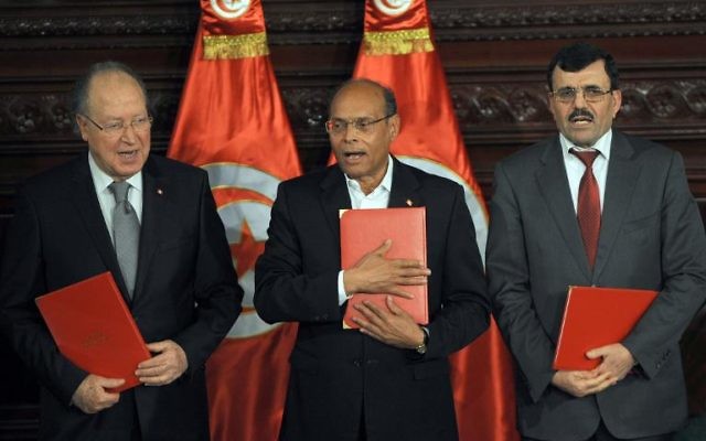Le chef de l'Etat tunisien Moncef Marzouki (c), le Premier ministre sortant Ali Larayedh (d) et le président de la Constituante, Mustapha Ben Jaafar (g) posent avec des copies de la nouvelle constitution, lors d'une cérémonie à Tunis, le 27 janvier 2014 
(Crédit : AFP/Fethi Belaid)