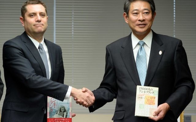 Le chef adjoint de l'ambassade d'Israël, Peleg Lewi (G) et Ryo Tanaka, le maire de l'arrondissement de Suginami à Tokyo lors d'une cérémonie pour le don de 300 exemplaires du Journal d'aNNe Frank, 27 février 2014 (Crédit : Toshifumi Kitamura/AFP)
