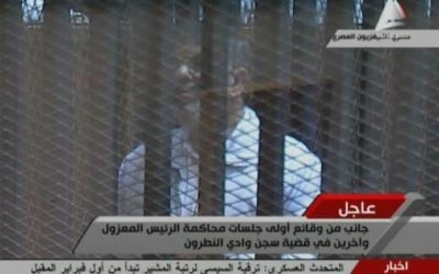 Image diffusée par la télévision égyptienne du président destitué Mohamed Morsi, portant l'uniforme blanc des détenus, au Caire le 28 janvier 2014.  (Crédit : TV égyptienne/AFP/Archives)