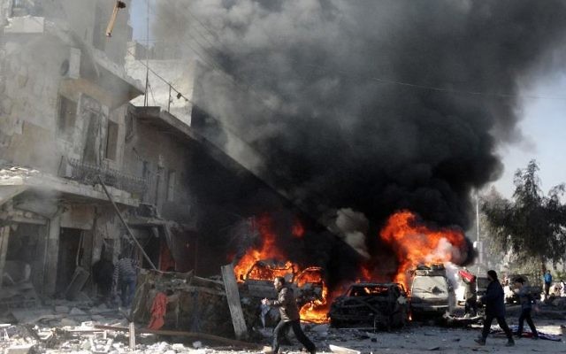 Des voitures en flammes après un bombardement sur la ville d'Alep, le 1er février 2014 
(Crédit : AFP/Mohammed Al-Khatieb)