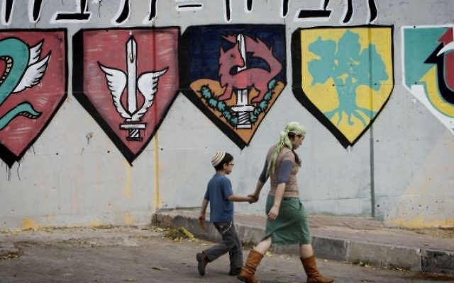 Des habitants juifs des implantations passent à côté d'une base de l'armée israélienne à Hébron. (Crédit : Miriam Alster/Flash90)