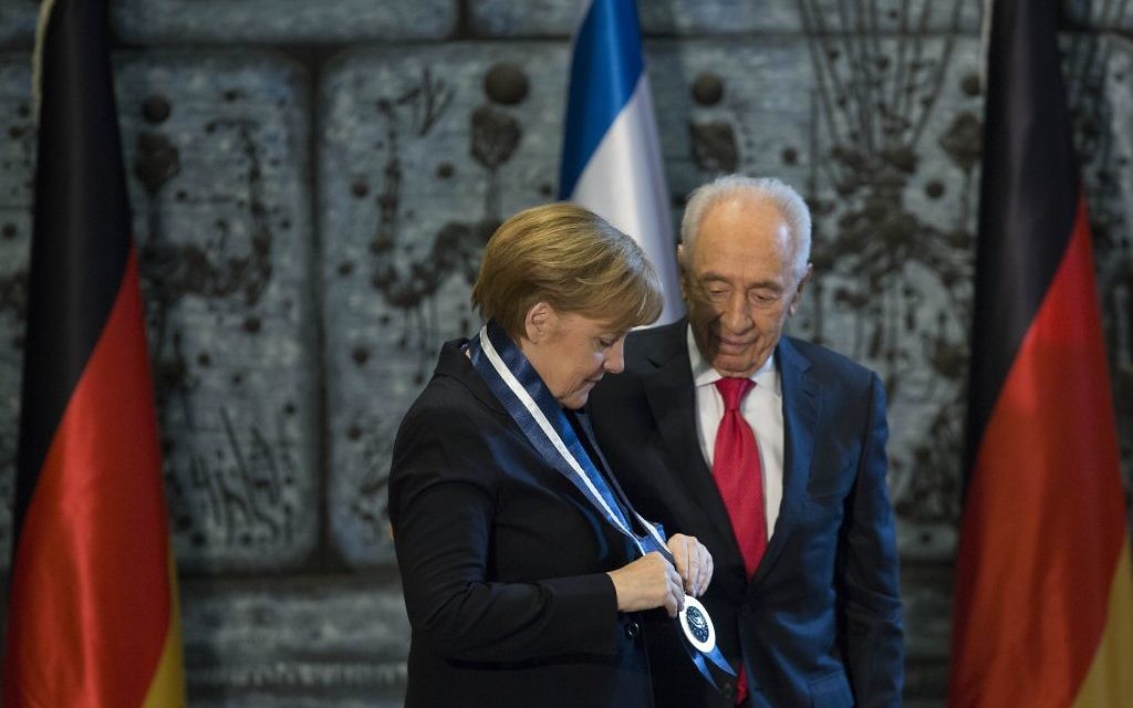 Le président Shimon Peres attribue la médaille présidentielle à la chancelière allemande Angela Merkel (Crédit : Yonatan Sindel/Flash90)