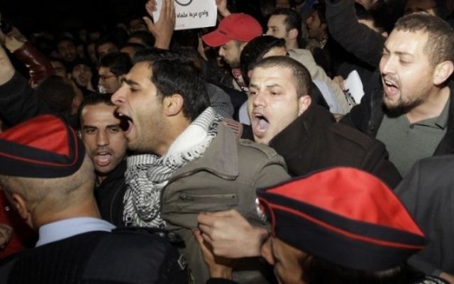 La police antiémeute tente de contrôle plusieurs centaines de manifestants jordaniens qui protestent devant l'ambassade israélienne et réclament le renvoi de l'ambassadeur à Amman, le 10 mars 2014 (Crédit : AFP/Khalil Mazraawi) La police antiémeute tente de contrôle plusieurs centaines de manifestants jordaniens qui protestent devant l'ambassade israélienne et réclament le renvoi de l'ambassadeur à Amman, le 10 mars 2014 (Crédit : AFP/Khalil Mazraawi)