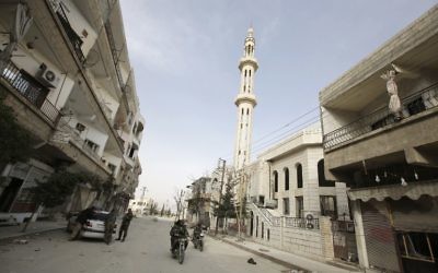 Des membres des forces pro-gouvernementales circulent dans les rues désertes de Yabroud après que les forces du régime, aidées du Hezbollah, aient repris le contrôle de la ville, le 16 mars 2014 (Crédit : AFP/JOSEPH EID)