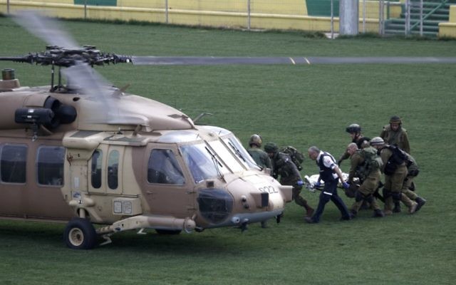 Des soldats israéliens transportent un soldat, blessé lors d'une explosion au plateau du Golan, vers un hélicoptère, le 18 mars 2014 (Crédit : AFP/Jalaa Marey) Des soldats israéliens transportent un soldat, blessé lors d'une explosion au plateau du Golan, vers un hélicoptère, le 18 mars 2014 (Crédit : AFP/Jalaa Marey)