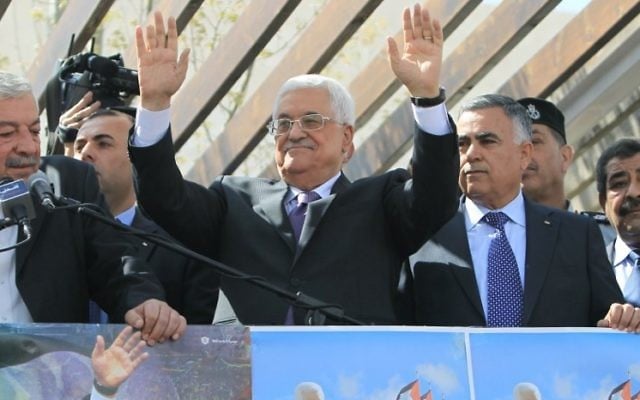 Le président de l’Autorité palestinienne Mahmoud Abbas salue les foules à son retour de sa visite officielle aux Etats-Unis, le 20 mars 2014 (Crédit : Abbas Nomani/AFP Photo)