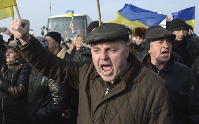 Des Ukrainiens manifestent au poste de contrôle qui bloque l'entrée en Crimée, le 7 mars 2014 (Crédit : Alexander Nemenov/AFP)