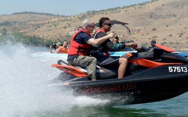Le Premier ministre Bejamin Netanyahu à bord d'un jet-ski sur la mer de Galilée lors de sa "Visite Royale" avec le producteur Peter Greenberg (Crédit : Avi Ohayon/Bureau de presse du gouvernement)
