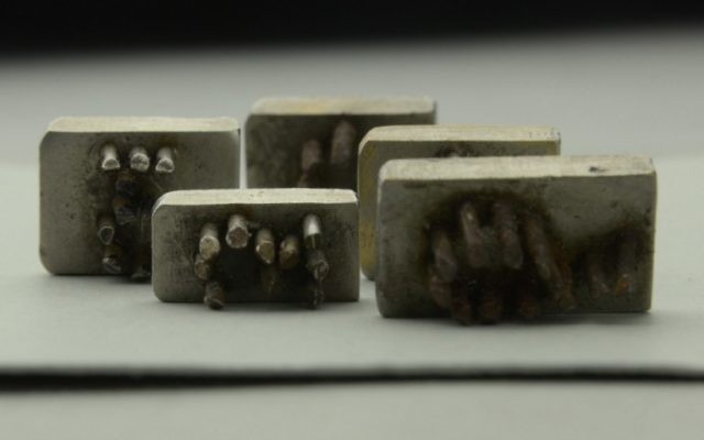 Cinq originaux rares de plaques métalliques à aiguilles trouvés à Auschwitz (Crédit : AFP)