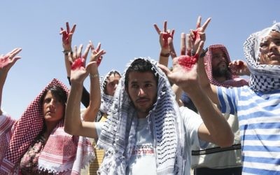 Des Israéliens recouverts d'un keffieh pour protester contre la libération de prisonniers (Crédit : Flash 90)