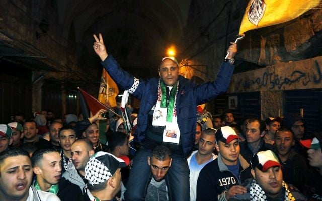Des Palestiniens portent un prisonnier libéré le 3 janvier 2014 dans la  Vieille Ville de Jérusalem (Crédit : Sliman Khader/Flash90)