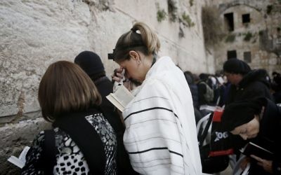 Une femme de l'organisation Neshot Hakotel porte les téfillines et le talith, normalement réservés aux hommes juifs orthodoxes, au Mur occidental, 3 mars 2014 (Crédit : Miriam Alster/FLASH90)