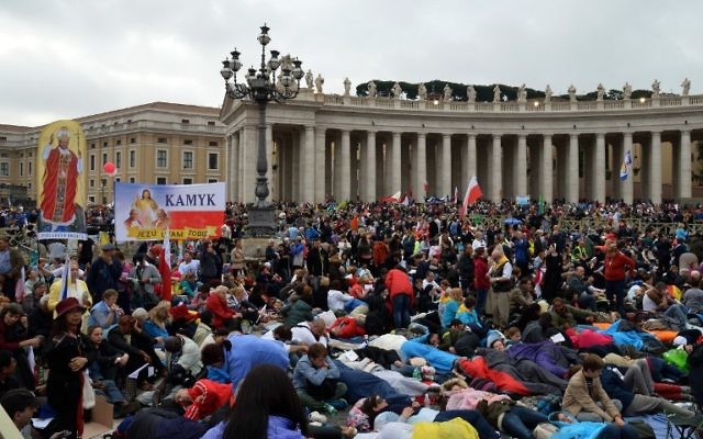 Des fidèles au Vatican en train d'attendre les cérémonies de canonisation de Jean XXIII et Jean-Paul II (Crédit : Alberto Pizzoli/AFP)