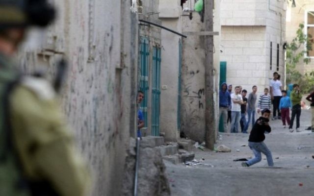 Un Palestinien utilise un lance-pierre pour lancer des pierres contre l'armée israélienne près du village palestinien d'Aïda (Crédit : Musa al-Shaer/AFP) Un Palestinien utilise un lance-pierre pour lancer des pierres contre l'armée israélienne près du village palestinien d'Aïda (Crédit : Musa al-Shaer/AFP)