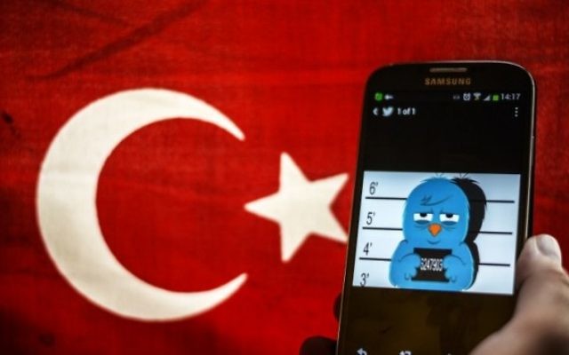 Une photo illustrant l'oiseau du logo de Twitter en état d'arrestation avec un drapeau turc en arrière-plan (Crédit : Ozan Kose/AFP)