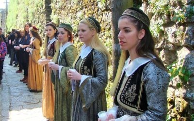 Des jeunes de la communauté juive de Ioannina, vêtu de robes traditionnelles, tiennent des bougies allumées à la mémoire des 500 enfants déportés à Auschwitz (Crédit : Gavin Rabinowitz/JTA)