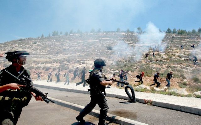 Gardes-frontières israéliens pendant des affrontements contre des manifestants palestiniens commémorant le 66e anniversaire de la "Nakba" dans le village de Walajah, en Cisjordanie, au sud de Jérusalem, le 15 mai 2014. (Crédit : Musa al-Shaer/AFP)
