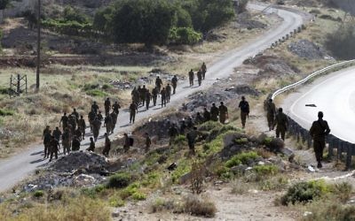 Des soldats israéliens en train de se diriger vers le village de Halhul, près de Hébron (Crédit : AFP/HAZEM BADER)