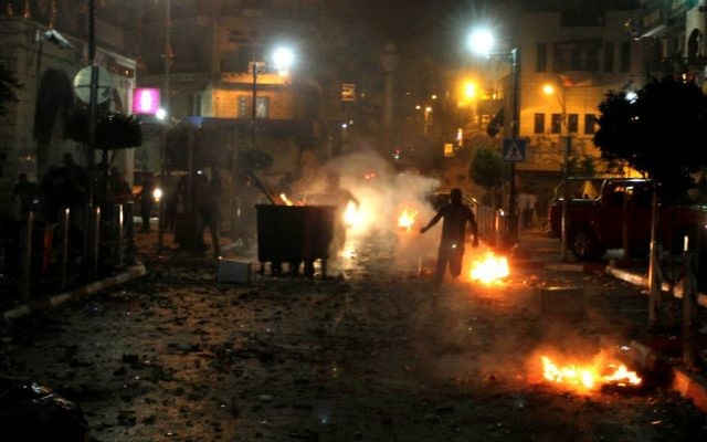 Des Palestiniens durant des affrontements avec les forces de sécurité israéliennes pendant les recherches des trois adolescents disparus le 22 juin 2014 dans ville de Ramallah en Cisjordanie (Crédit : Issam Rimawi/Flash 90)