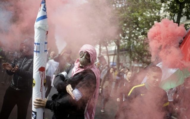 Un manifestant français à Paris qui fait une quenelle en portant un masque et une fausse roquette - 13 juillet 2014 (Crédit : AFP) Un manifestant français à Paris qui fait une quenelle en portant un masque et une fausse roquette - 13 juillet 2014 (Crédit : AFP)