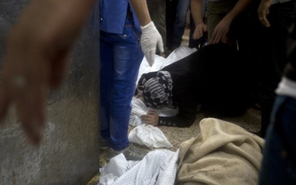 Une femme pleurant le corps d'un mort à l'hopital de Shifa (Crédit : AFP/MAHMUD HAMS)