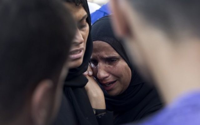 Une femme palestinienne pleure la mort d'un membre de sa famille à l'extérieur de l'hôpital Shifa (Crédit : AFP/MAHMUD HAMS)