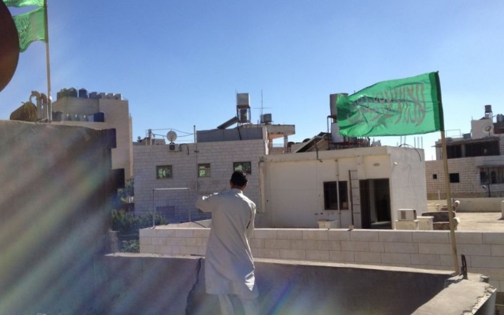 Le drapeau du Hamas qui flotte au-dessus d'une maison (Crédit : Elhanan Miller/Times of Israel)