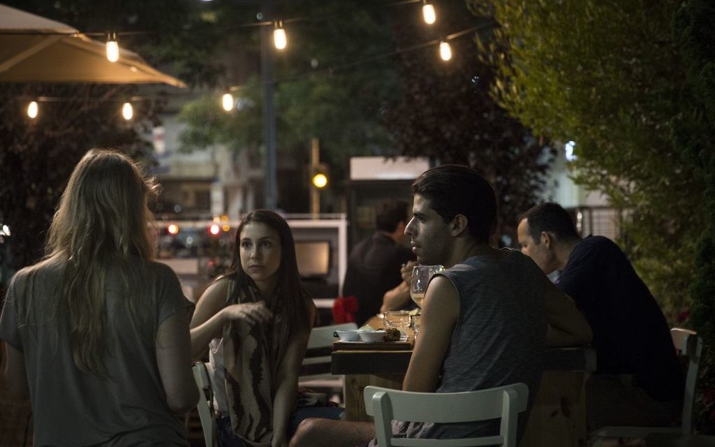 Des Israéliens prennent un verre peu après un retentissement de sirènes à Tel Aviv - 8 juillet 2014 (Crédit : Hadas Parush/Flash90) Des Israéliens prennent un verre peu après un retentissement de sirènes à Tel Aviv - 8 juillet 2014 (Crédit : Hadas Parush/Flash90)