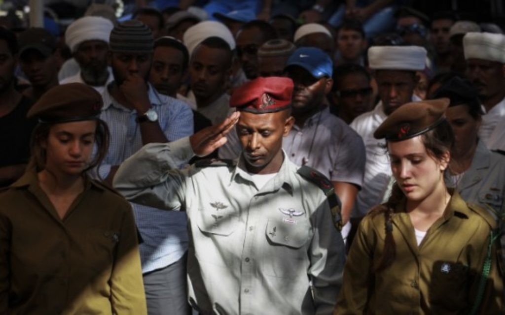 Un soldat éthiopien salue la tombe du soldat Golani, Moshe Malko, au cimetière militaire de Har Herzl à Jérusalem, le 21 Juillet 2014. Moshe Malko, 20 ans, de Jérusalem, a été tué lors des combats dans la bande de Gaza. (Crédit : Hadas Parush/Flash90)