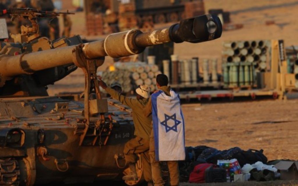 Des soldats israéliens près d'un char d'artillerie dans la bande de Gaza (Crédit : Mendy Hechtman/Flash90) Des soldats israéliens près d'un char d'artillerie dans la bande de Gaza (Crédit : Mendy Hechtman/Flash90)