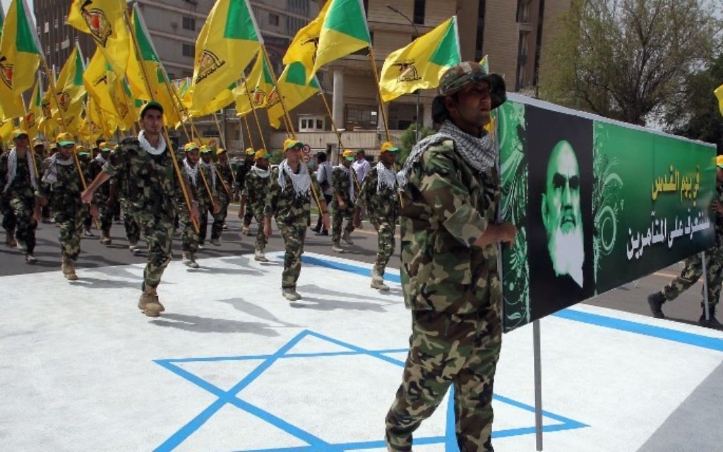 Membres irakiens du Hezbollah tiennent les drapeaux jaunes de la branche irakienne du parti chiite et un portrait de guide spirituel de l'Iran, l'ayatollah Ruhollah Khomeini, et ils marchent sur un drapeau israélien peint sur le sol pendant la journée d'al-Qods (Jérusalem) - 25 Juillet 2014, la capitale irakienne Bagdad. (Crédit : AFP / Ali al-Saadi) Membres irakiens du Hezbollah tiennent les drapeaux jaunes de la branche irakienne du parti chiite et un portrait de guide spirituel de l'Iran, l'ayatollah Ruhollah Khomeini, et ils marchent sur un drapeau israélien peint sur le sol pendant la journée d'al-Qods (Jérusalem) - 25 Juillet 2014, la capitale irakienne Bagdad. (Crédit : AFP / Ali al-Saadi)