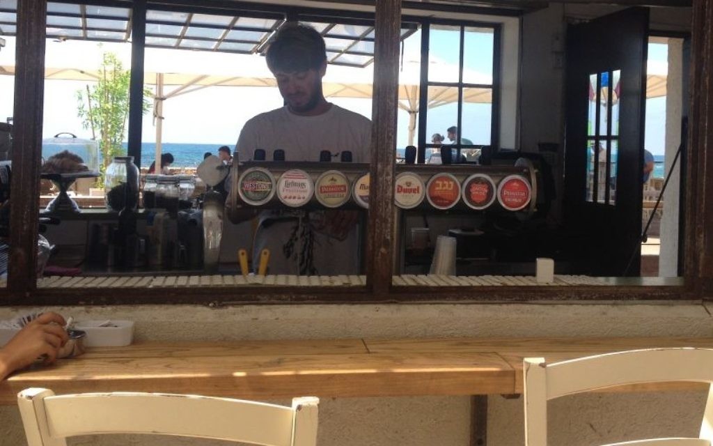 Roi Sterman, un étudiant de l'Université Bar Ilan qui sert au bar au port de Jaffa, dit que l'entreprise a été mauvaise pendant deux mois, mais il y a un flux constant de touristes de la Cisjordanie, pour célébrer l'Aïd al-Fitr (Crédit : Jessica Steinberg / Times of Israël) Roi Sterman, un étudiant de l'Université Bar Ilan qui sert au bar au port de Jaffa, dit que l'entreprise a été mauvaise pendant deux mois, mais il y a un flux constant de touristes de la Cisjordanie, pour célébrer l'Aïd al-Fitr (Crédit : Jessica Steinberg / Times of Israël)
