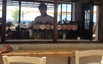 Roi Sterman, un étudiant de l'Université Bar Ilan qui sert au bar au port de Jaffa, dit que l'entreprise a été mauvaise pendant deux mois, mais il y a un flux constant de touristes de la Cisjordanie, pour célébrer l'Aïd al-Fitr (Crédit : Jessica Steinberg / Times of Israël)