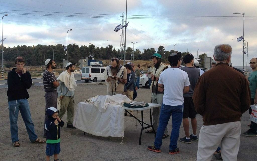 Israéliens réunis pour les prières à l'intersection du Gush Etzion avant de rejoindre les Palestiniens locaux pour un repas en commun pour rompre le jeûne (Crédit : Jessica Steinberg/Times of Israel)
