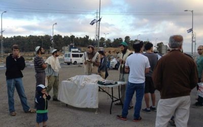 Israéliens réunis pour les prières à l'intersection du Gush Etzion avant de rejoindre les Palestiniens locaux pour un repas en commun pour rompre le jeûne (Crédit : Jessica Steinberg/Times of Israel)