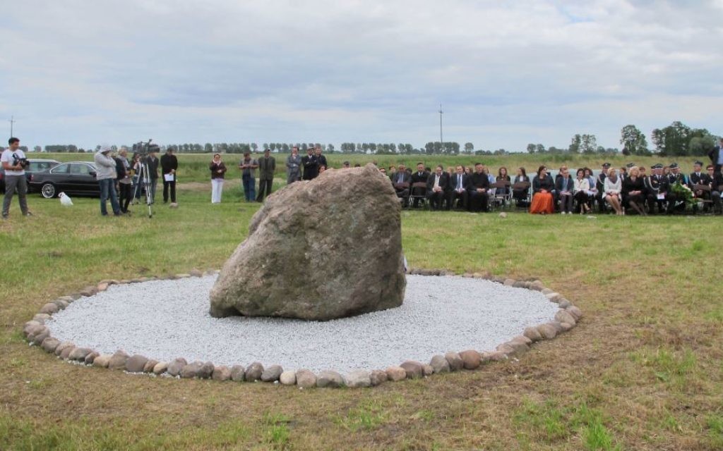 Une petite foule assiste à la cérémonie d'inauguration d'un monument au cimetière juif à Rychwal, Pologne. (Crédit : Ruth Ellen Gruber / JTA)