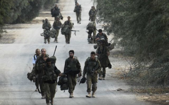 Soldats israéliens à pied près de la frontière entre Israël et la bande de Gaza qui reviennent de l'enclave côtière palestinienne contrôlée par le Hamas, le mardi 5 août 2014 (Crédit : AFP / DAVID BUIMOVITCH) Soldats israéliens à pied près de la frontière entre Israël et la bande de Gaza qui reviennent de l'enclave côtière palestinienne contrôlée par le Hamas, le mardi 5 août 2014 (Crédit : AFP / DAVID BUIMOVITCH)